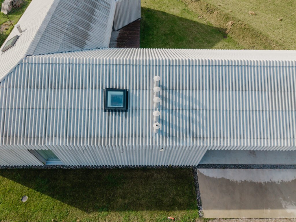 Už standarto ribų: vientisa banguotųjų stogo ir fasado lakštų architektūra 14 Individualus namas Kaune – banguotų lakštų stogas.