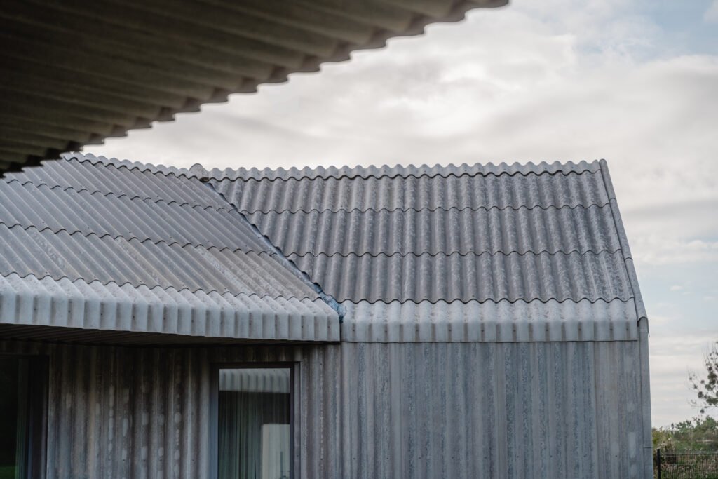 Už standarto ribų: vientisa banguotųjų stogo ir fasado lakštų architektūra 13 Individualus namas Kaune – banguotų lakštų stogas.